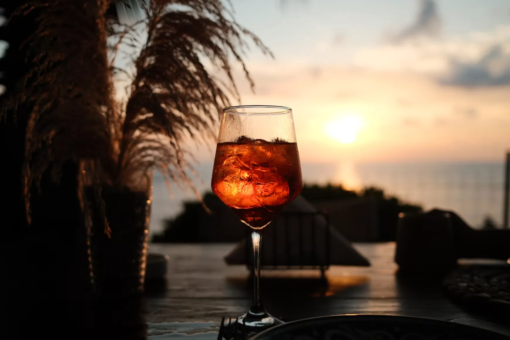 An Aperol Spritz on a terrace at sunset by the sea