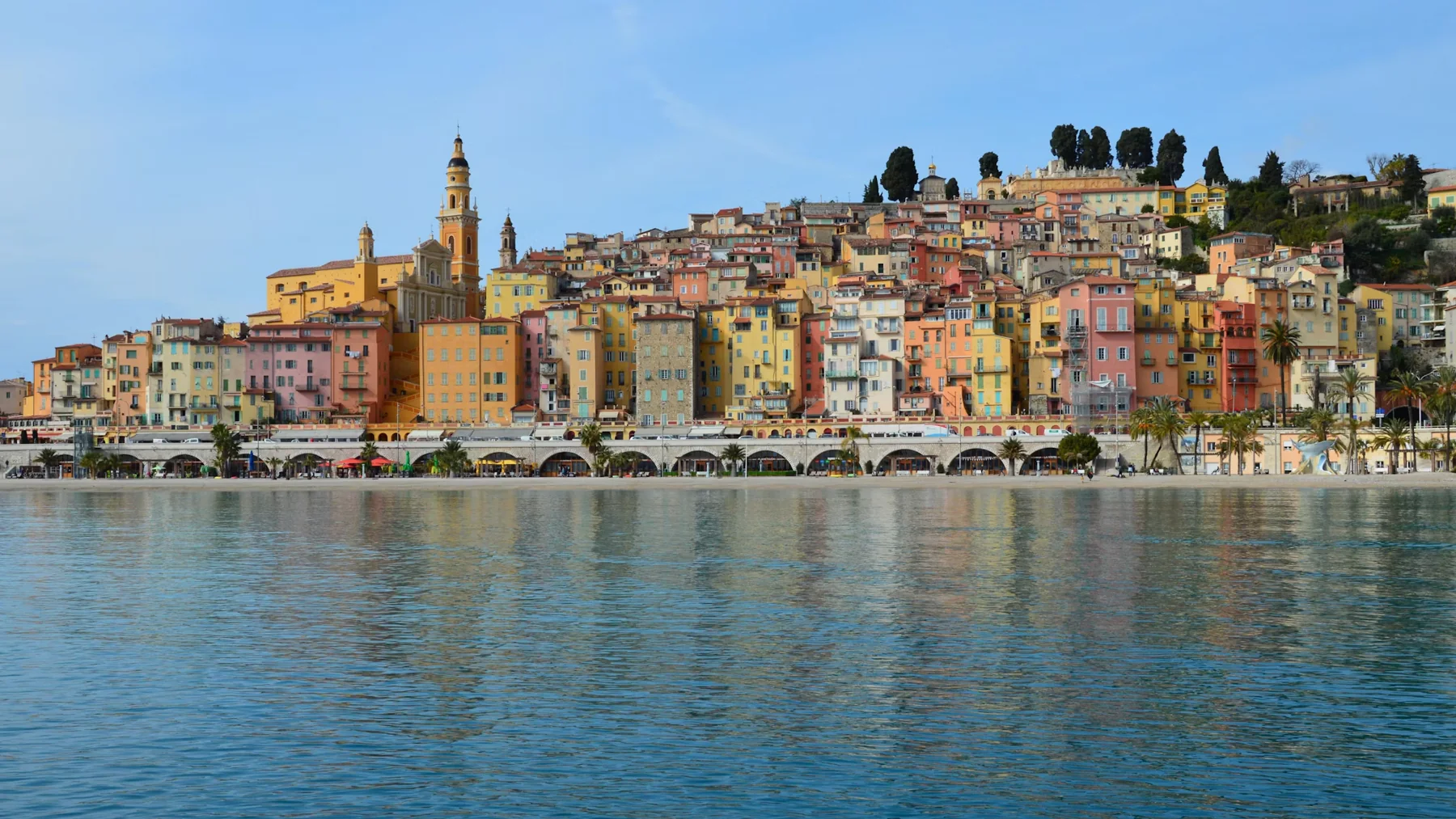 Menton old town with its colourful houses and the Basilica bell tower above the sea
