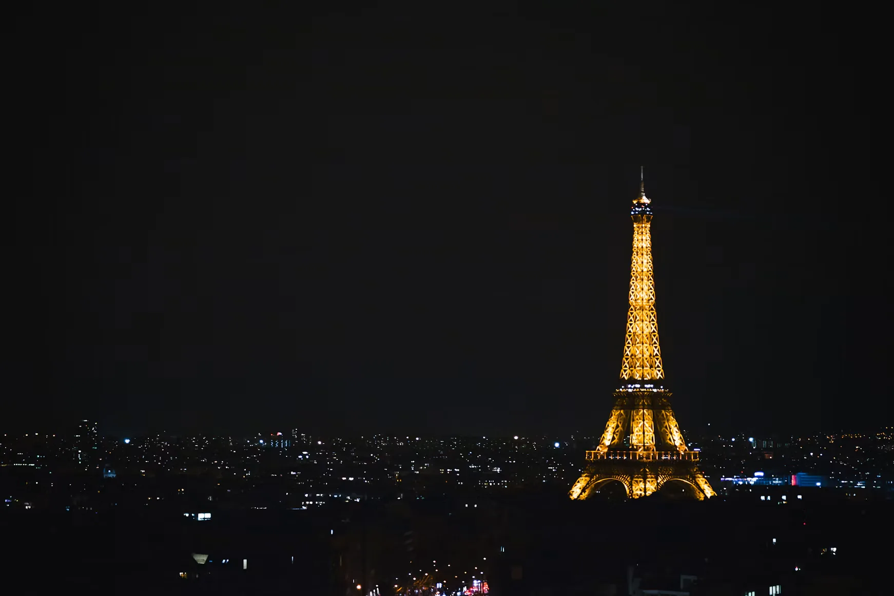 The Eiffel Tower glowing over Paris at night